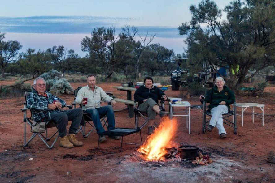 Mt Finke Googs Track SA campsite, friends aroud campfire in desert, camp chair