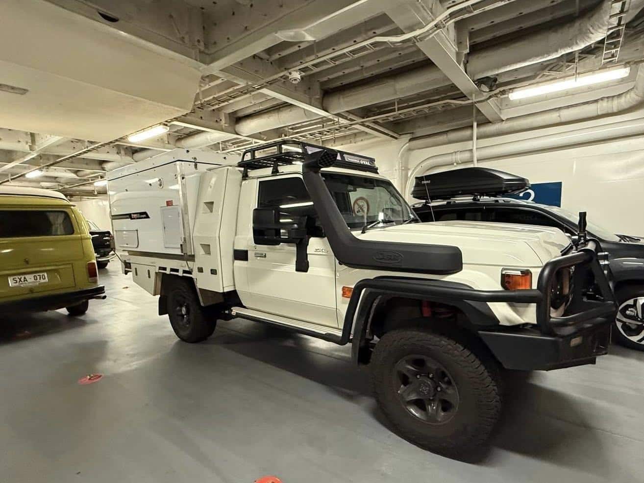 White Land Cruiser 79 series Ute with a Trayon slide-on camper parked on the ferry the spirit of Tasmania