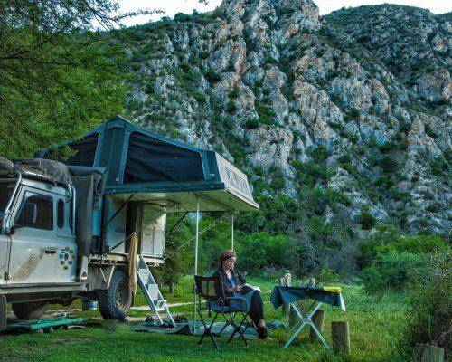 Trayon Camper awning parked in a scenic mountain landscape with lush vegetation
